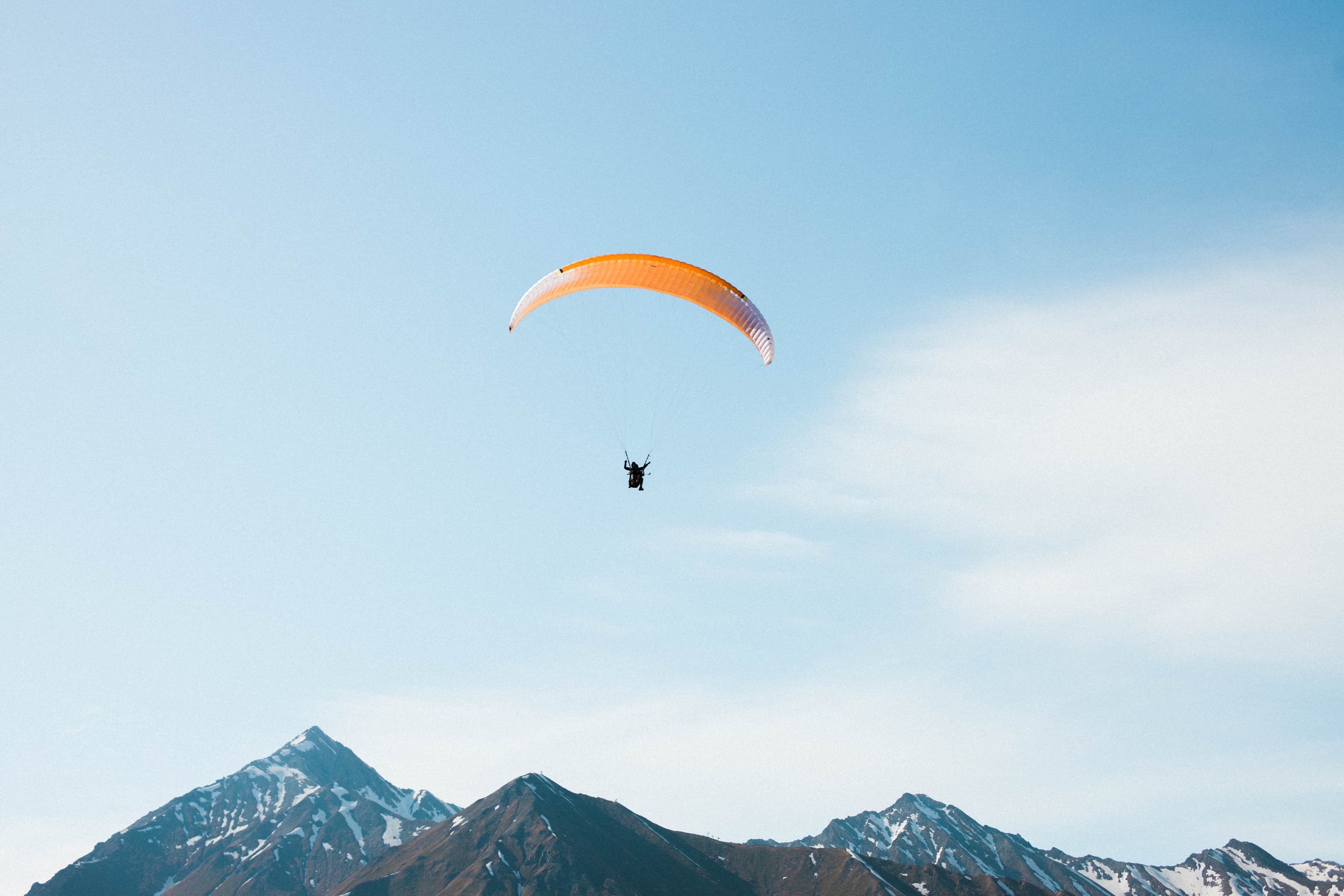 Paraglider soaring over mountains